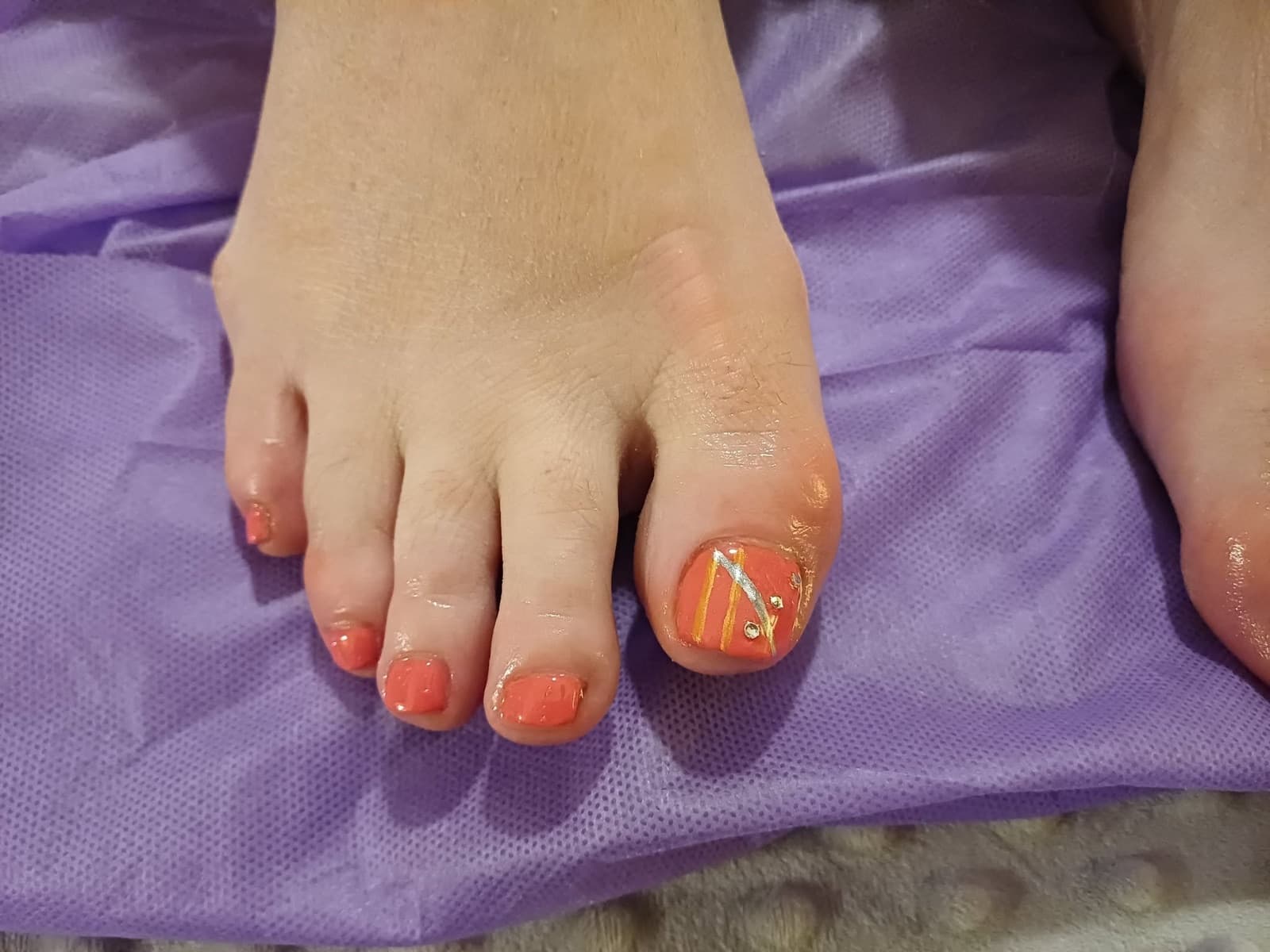 Coral pedicure with gold and silver nail art